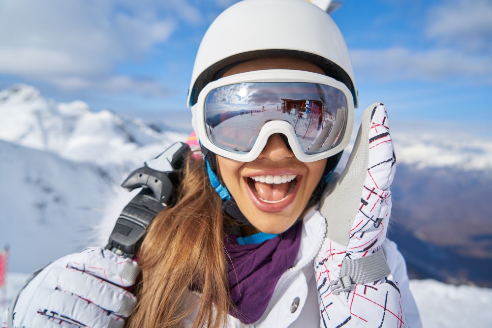 Kvinde i skidragt med sne i baggrunden